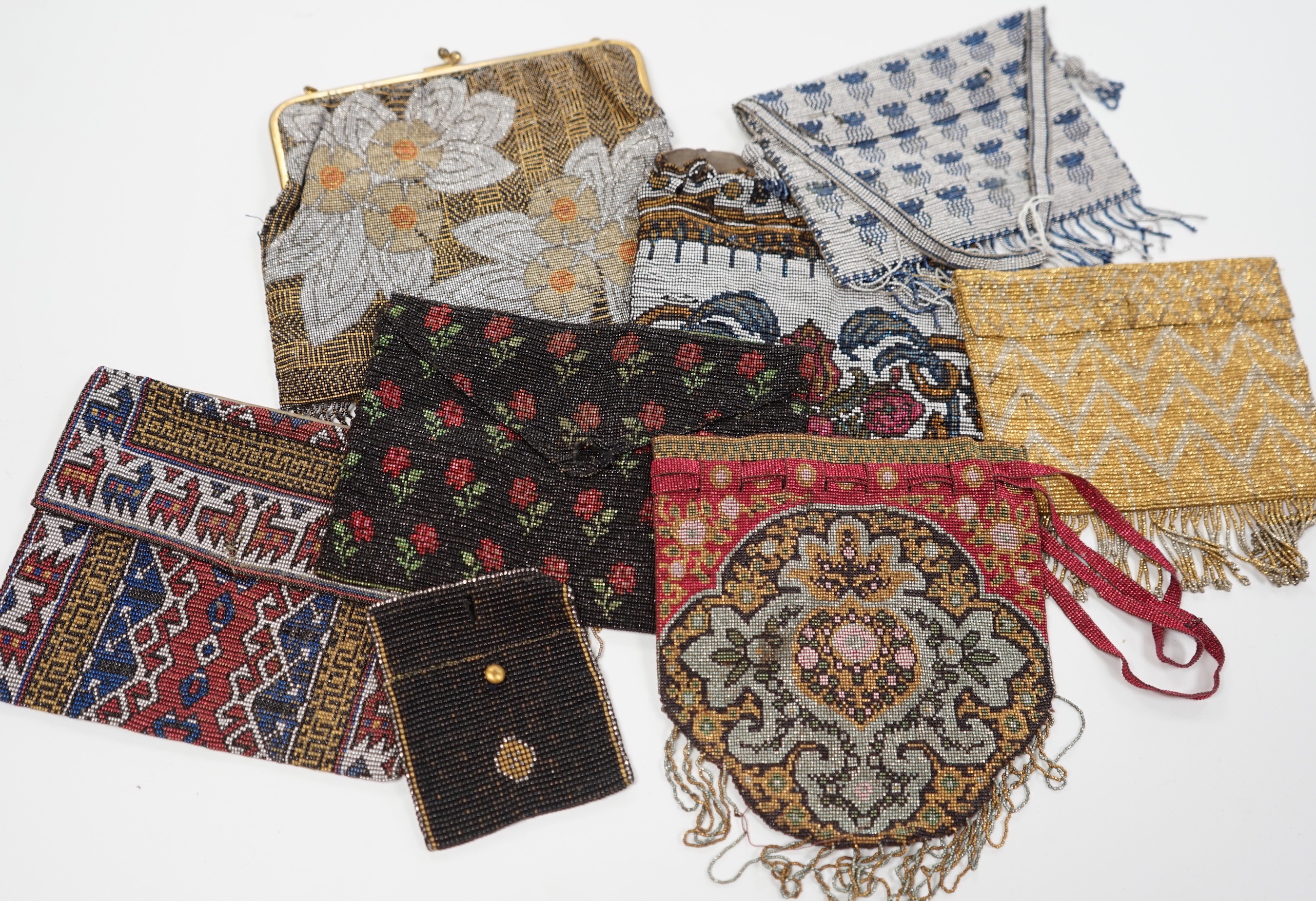 Seven late 19th century multicoloured and designed cut steel evening bags and a small coin purse (8)